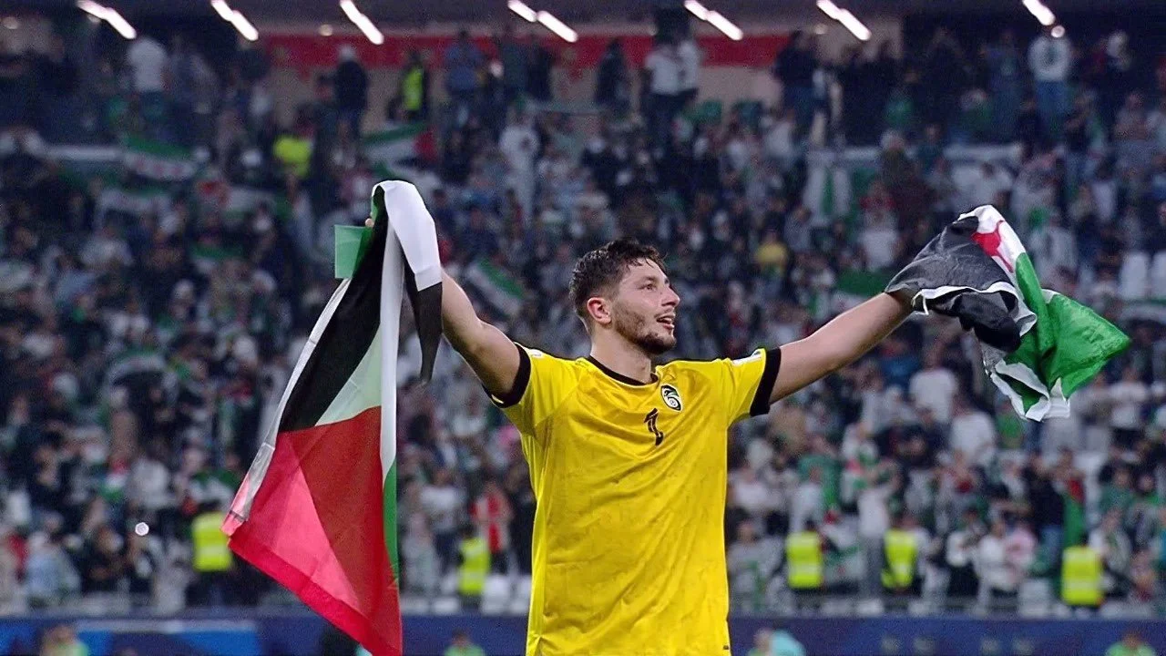 إلياس هدايا حارس منتخب سوريا يرفع علمي سوريا وفلسطين بعد التأهل سويًا.